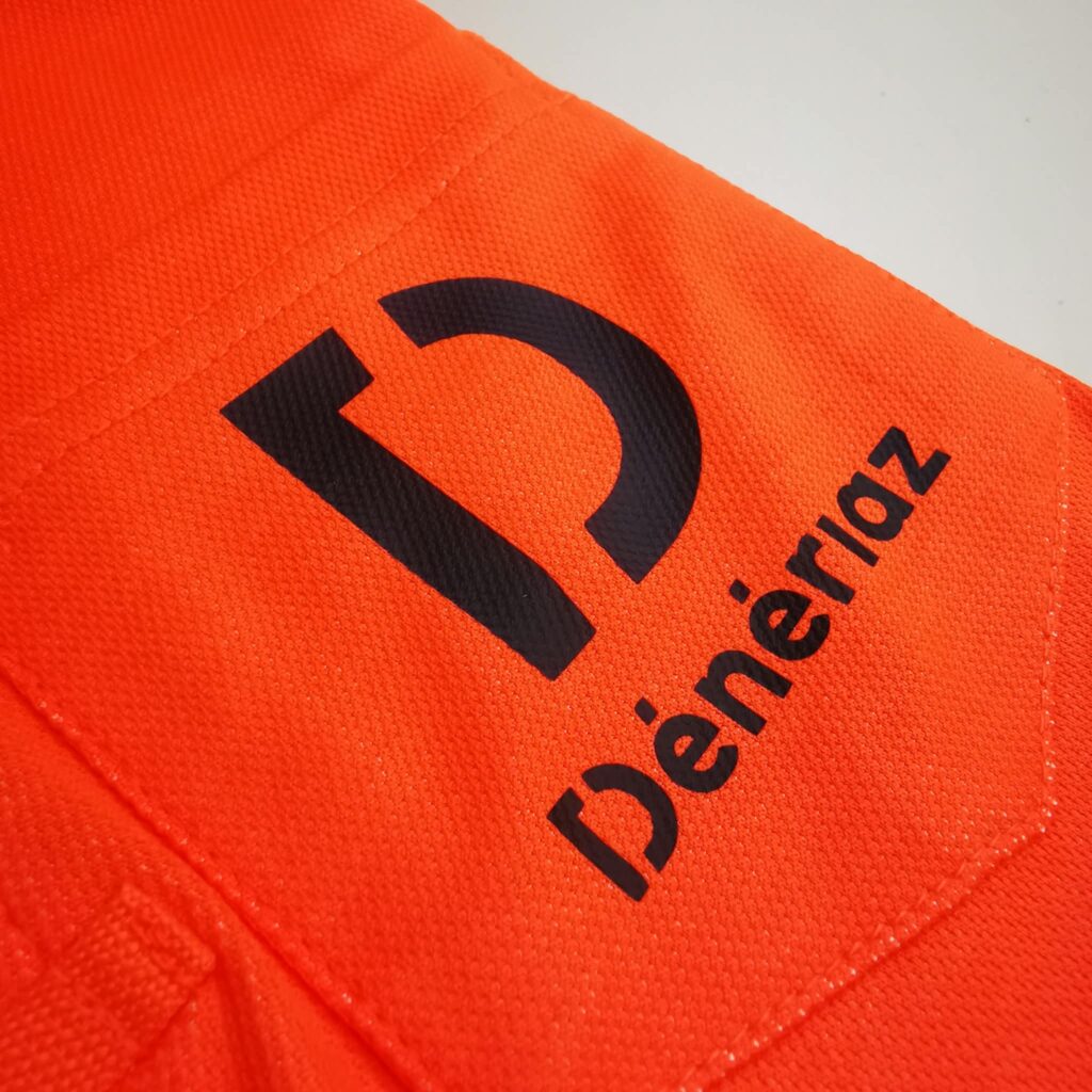 Gros plan sur le logo Dénériaz noir sur textile orange