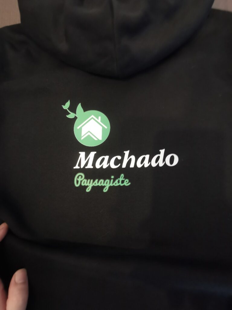 Logo Machado Paysagiste blanc et vert sur textile noir